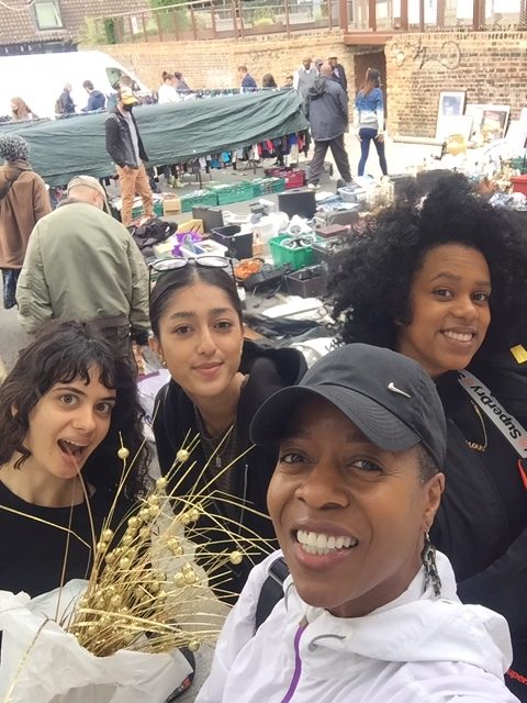 A group over head selfie of Linett, Amelia, Azarra and Safa.In the background you can see Deptford Market.